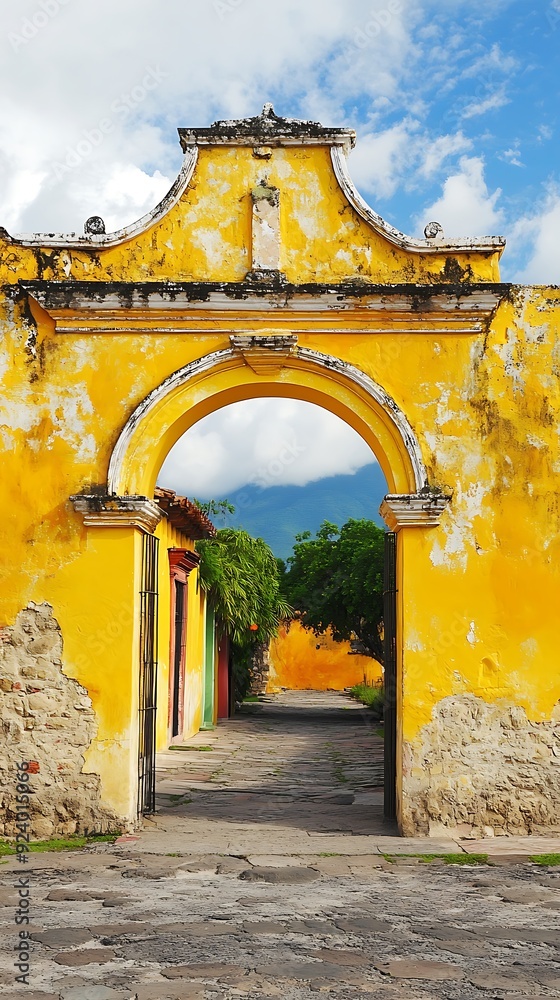 Poster yellow archway leading to a stone path and a view of lush greenery and mountains