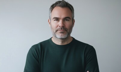 Fototapeta premium middle aged man with grey hair and short beard wearing dark green sweater