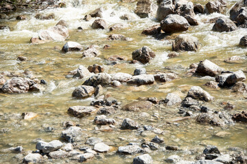 water flowing through pebbles in stream