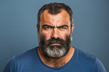 Obraz premium A man with a beard and a blue shirt is staring at the camera