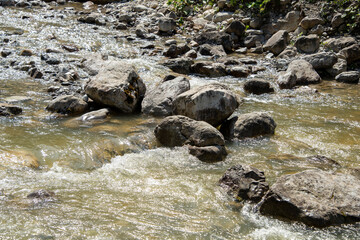 water flowing through pebbles in stream