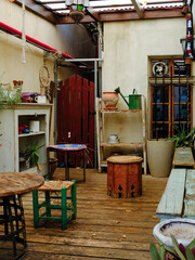 Cozy vintage backyard with rustic garden furniture, eclectic decor, and potted plants creating a bohemian atmosphere.