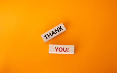 Thank you symbol. Wooden blocks with words Thank you. Beautiful orange background. Business and...