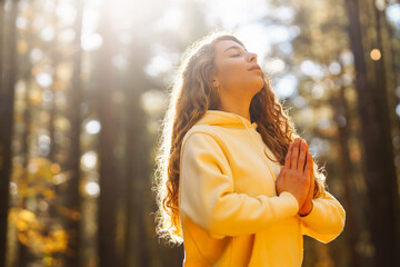 Morning yoga and meditation in peaceful natural forest. Pretty woman doing yoga exercises. Heather...