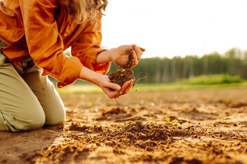 Soil is land in the hands of the farmer. Land plot close-up of hands of farmer mud peat. Garden nature. Ecology of fertile soil. The farmer works in the field. Environment in countryside.