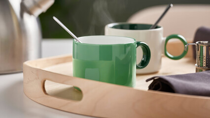Closeup of white and green ceramic cups in a wooden tray.