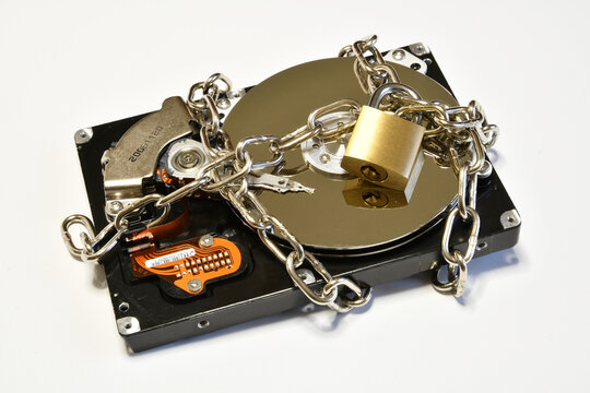 Open hard drive secured with an iron chain and padlock. Cyber ​​security concept. Data of hard drive secured by padlock