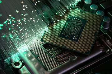 Detail of Detail of the CPU on a PC motherboard illuminated by a fiber optic lamp. Hi-tech technology color background