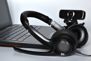 Notebook with headphones with mic and a webcam, concept of smart working or online communications.