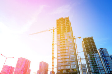 Fototapeta premium Construction site on sunset blue sky. Construction of Residential Building. Tower Crane on formworks. House Construction. Tower Cranes on Residential buildings Construction on blue sky background.