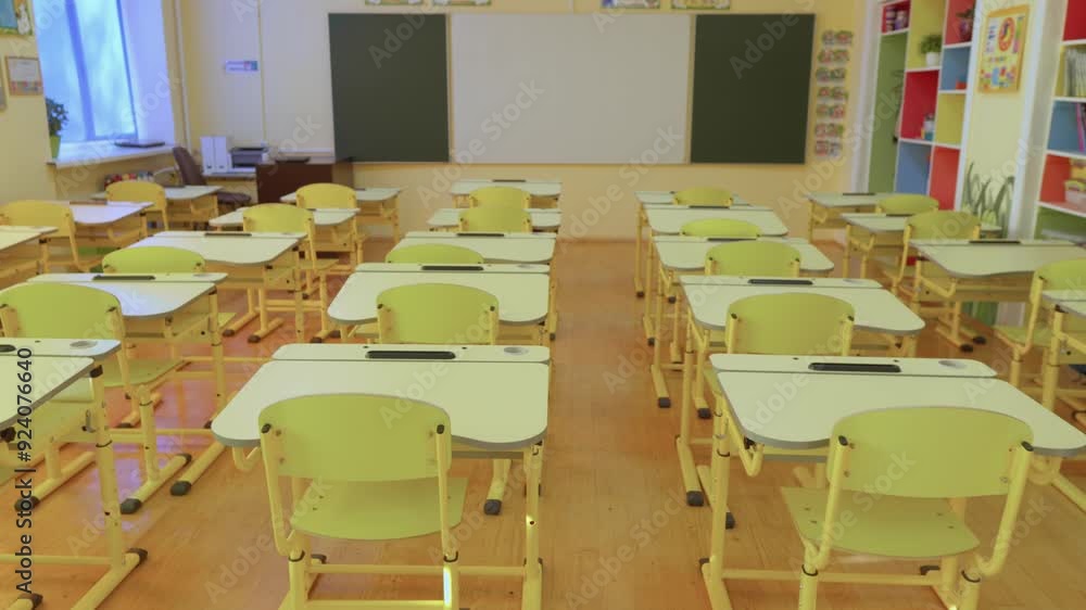 Aufkleber A bright and clean classroom in a school equipped with desks and a chalkboard is ideal for educational activities and teaching. It creates a suitable environment for lectures and studying