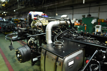 Truck production line. Assembly line. Engine install on frame of Wheel chassis of Heavy duty truck plant. Workshop production of Heavy duty trucks. Trucks Manufacture. Assembly line of truck factory.
