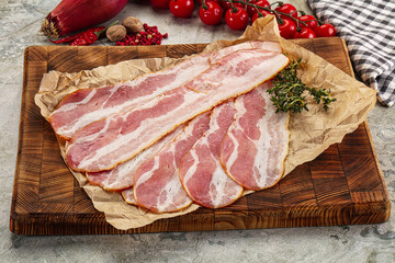 Sliced pork bacon over board