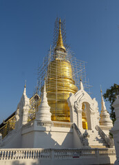 Whitewashed chedi of Wat Suan Dok covered with bamboo scaffolding in Chiang Mai, Thailand