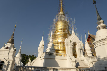 Fototapeta premium Whitewashed chedi of Wat Suan Dok covered with bamboo scaffolding in Chiang Mai, Thailand