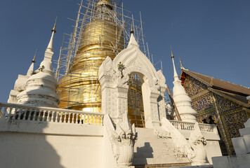 Whitewashed chedi of Wat Suan Dok covered with bamboo scaffolding in Chiang Mai, Thailand