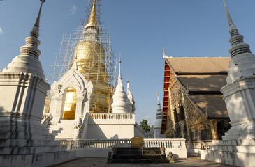 Fototapeta premium Whitewashed chedi of Wat Suan Dok covered with bamboo scaffolding in Chiang Mai, Thailand