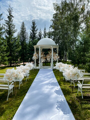 There exists a beautiful white carpet gracefully leading up to a charming gazebo that is...