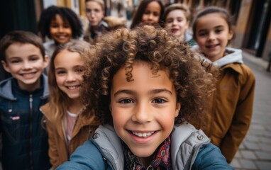 A group of children with curly hair are smiling for a picture. Scene is happy and cheerful