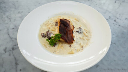 Rigatoni Carbonara Pasta with Crispy Bacon Served in Creamy White Sauce on Marble Table