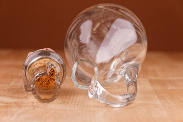 Broken glass bottle with cork on wooden table, broken structure
