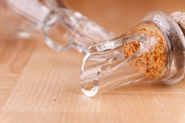 Broken glass bottle with cork on wooden table, broken structure