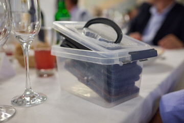 A Compact Storage Container Positioned on the Table Featuring Various Pieces of Glassware inside phones so you don't get distracted during dinner