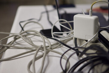 A Messy Arrangement of Tangled Cables and Chargers on a Surface or Busy Desktop Area