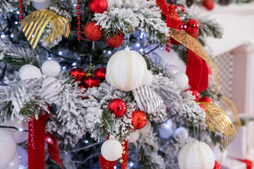 The Christmas tree is decorated for Christmas. Beautifully decorated house with red, silver, white balls on Christmas tree and presents. A magical time. happy New Year