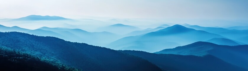 Fototapeta premium A mesmerizing view of blue mountains stretching into the horizon, enveloped in mist and creating a serene and tranquil atmosphere.