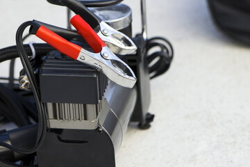pump compressor for inflating car wheels close-up. Car pump in a black case on a gray background....
