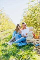 Fototapeta premium Father and mother holding little son in nature, concept of beautiful family bonds. Family portrait of parents with a little son. The concept of a happy family