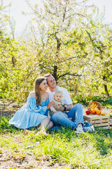 Fototapeta premium Father and mother holding little son in nature, concept of beautiful family bonds. Family portrait of parents with a little son. The concept of a happy family