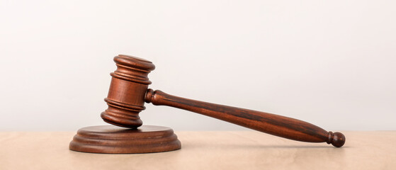 Judge's gavel on table against light background