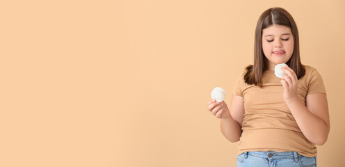 Overweight girl eating tasty marshmallow on color background