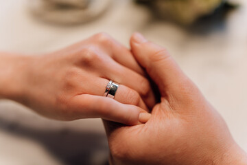Romantic engagement moment, couple holding hands with rings, celebrating love and commitment