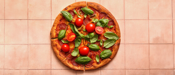 Delicious Pepperoni pizza with tomatoes and basil on pink tile background