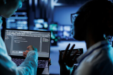 Trained programmers build firewall systems in server room housing advanced infrastructure. Skilled...