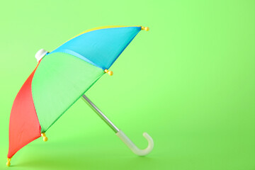 Mini colorful umbrella on green background
