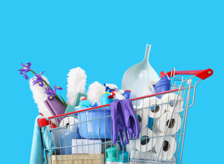 Shopping cart full of cleaning supplies and purple flowers on blue background