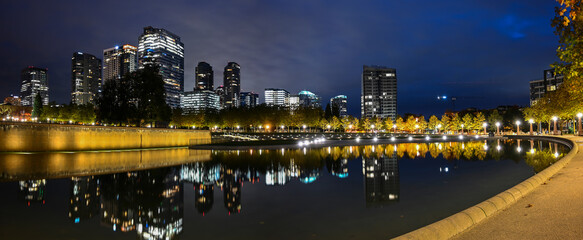 A panoramic early morning, predawn view of the Downtown Bellevue Park with downtown buildings in the background, lights and reflections in the park water feature_10242020_002.