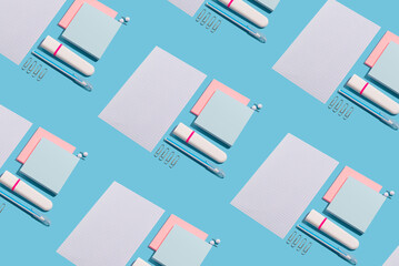 Highlighter, pen, push pins and paper sheets on blue background. Office and school supplies on blue...