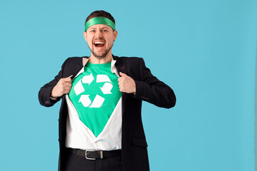 Young man dressed as eco superhero on blue background. Ecology concept