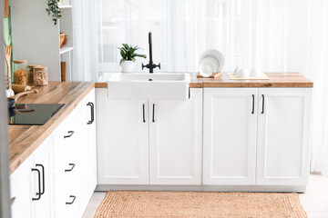 Interior of modern kitchen with stylish sink and kitchenware