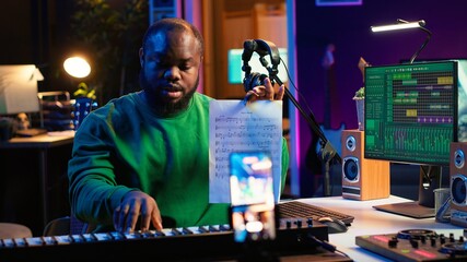 Talented composer explaining musical sheet notes during online master class recorded with...