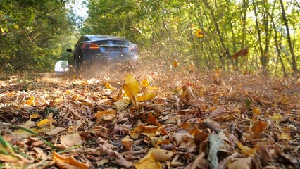 Powerful electrical car crossing through alley. Black electric sedan driving fast along an empty...