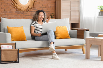 Obraz premium Beautiful middle-aged woman with red string on her finger and laptop at home. Reminder concept