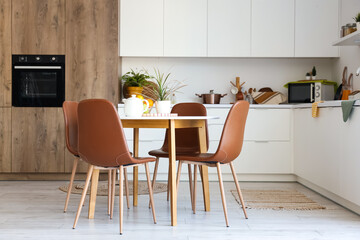 Interior of light kitchen with dining table and counters
