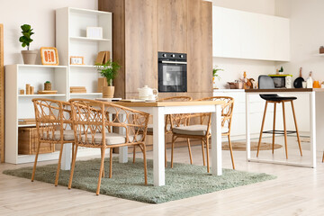 Interior of cozy kitchen with dining table and shelf units