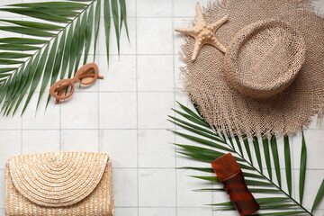 Beautiful composition with beach accessories and sunscreen on tile background